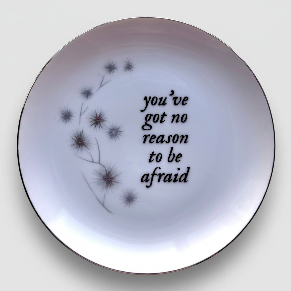 White plate with black text and floral design on a colorful background